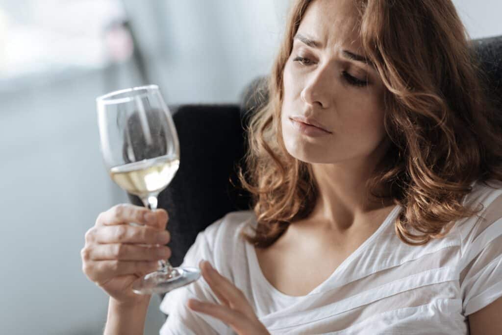 woman with glass of wine wonders if she has alcohol use disorder