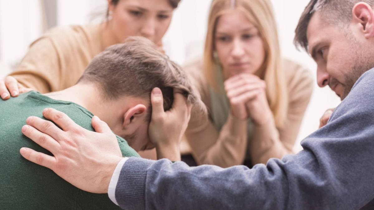 Family supporting young man and actively listening to him; one of the best ways to understand how to help someone with addiction. 