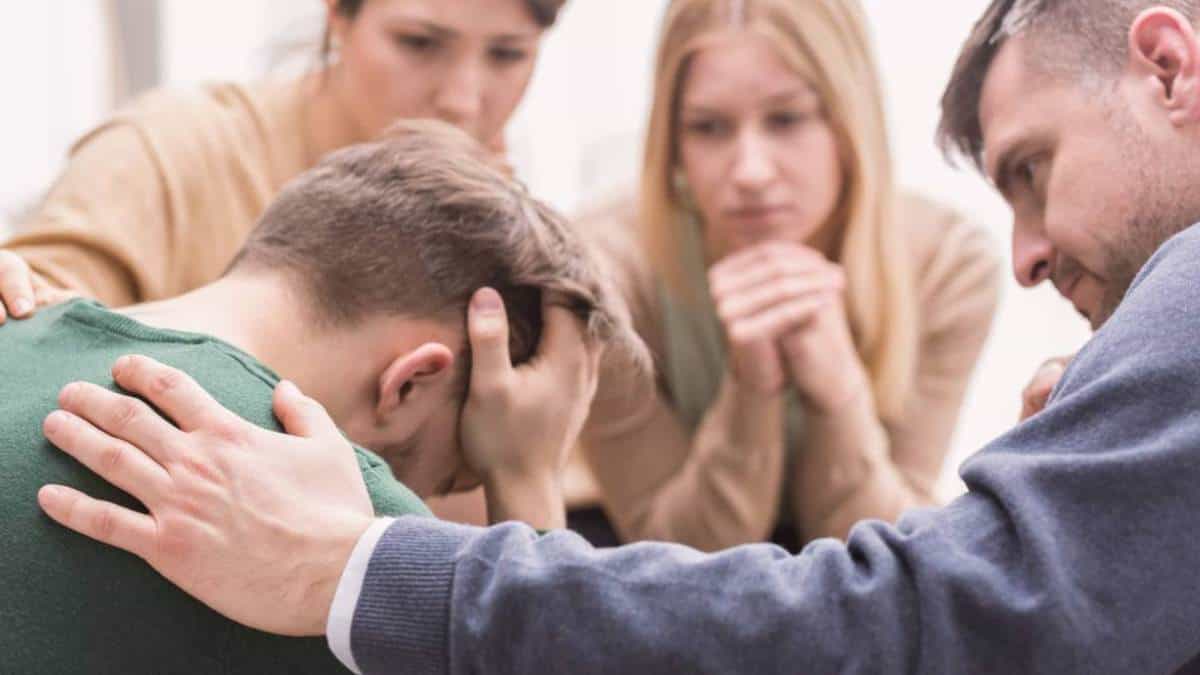 Family encouraging young man to begin alcohol rehab in New Jersey.
