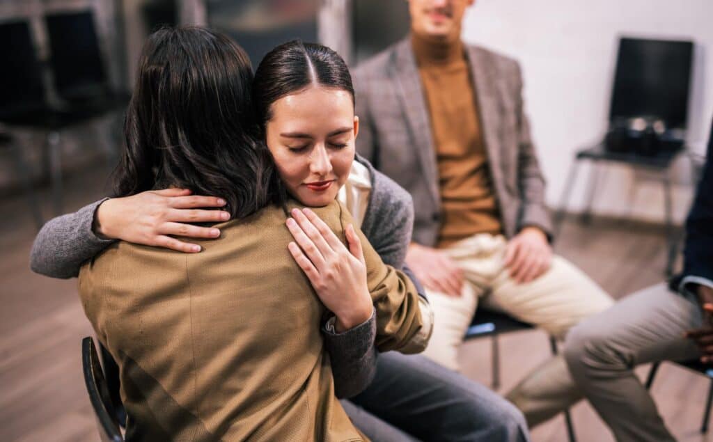 Woman hugging a loved one during group therapy in fentanyl addiction treatment in New Jersey.