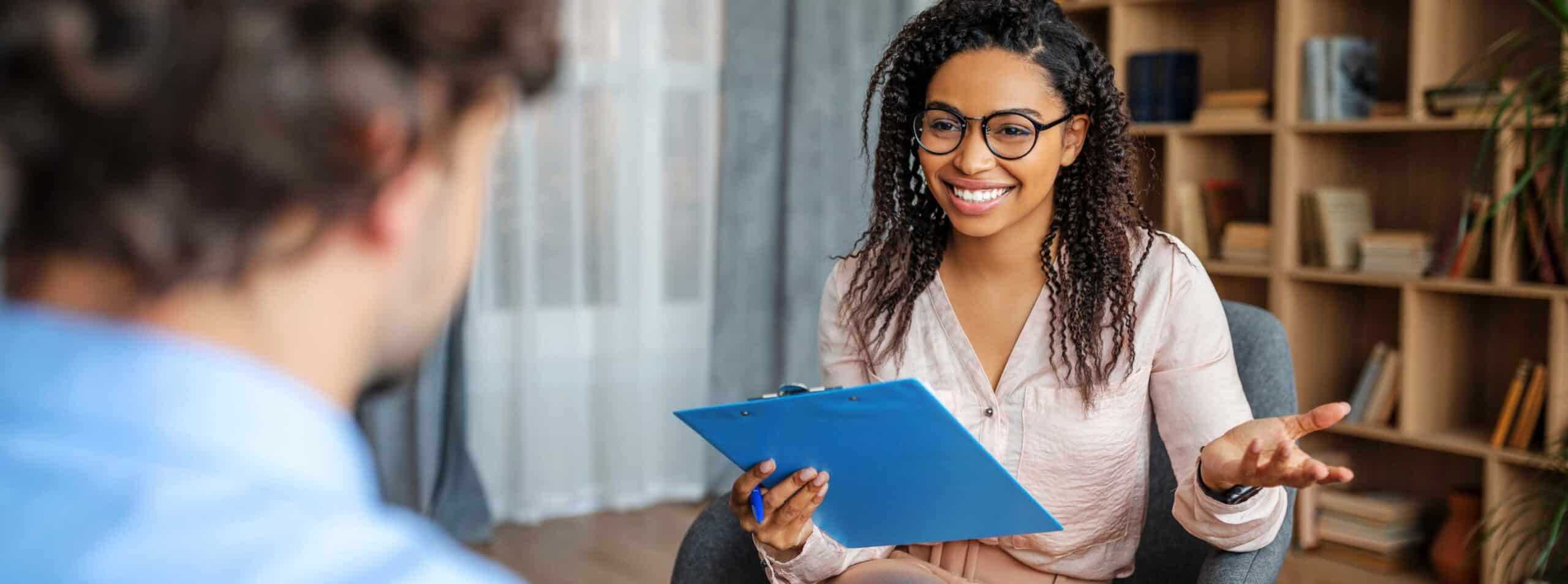 Smiling therapist speaking with a client in a Philadelphia addiction treatment setting.