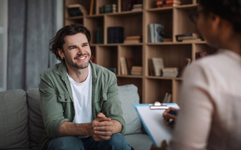 Man smiling during therapy for trauma and addiction.