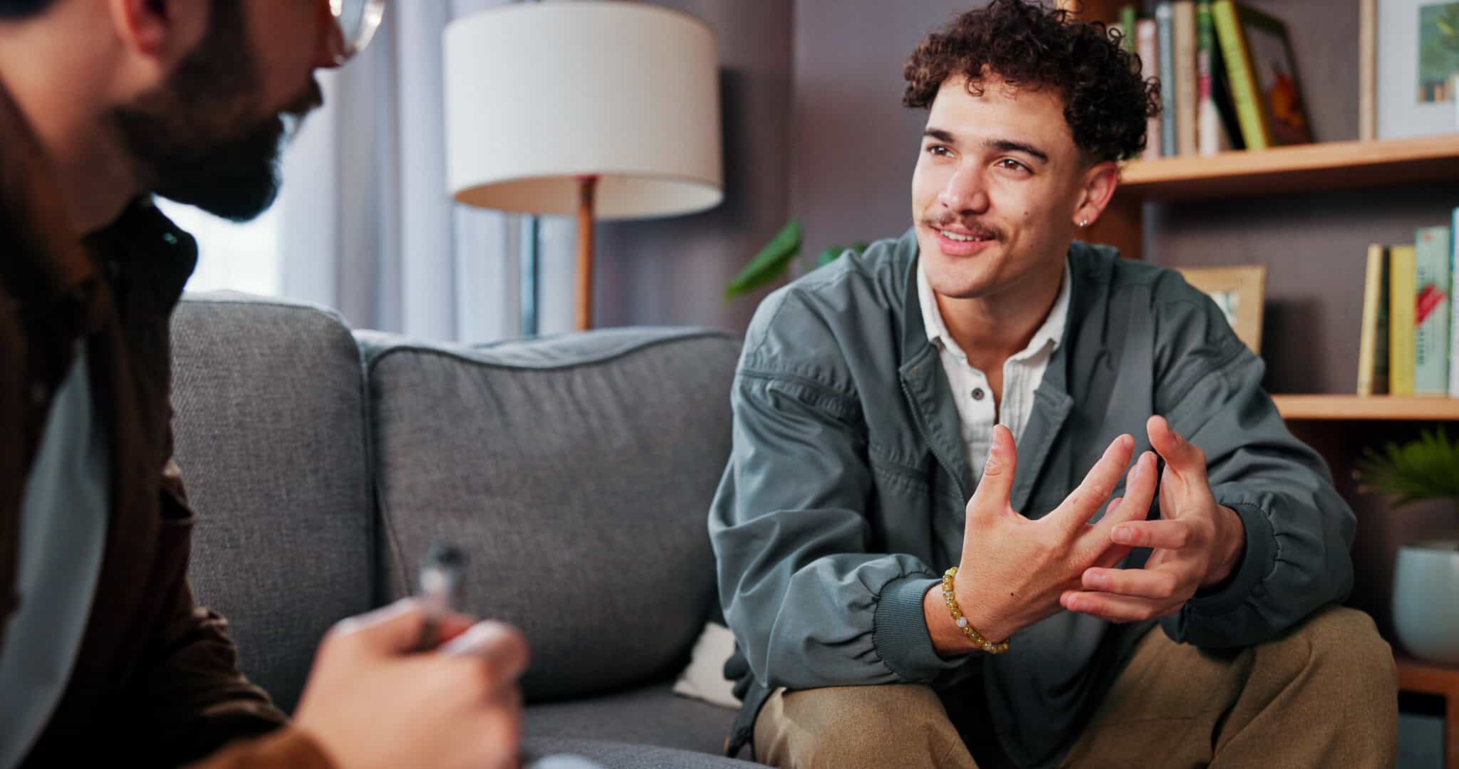 Psychology, therapist and happy man talking for help, mental health advice or support in office. Counseling session, life coach and people in therapy for assessment, consultation and evaluation for aetna drug rehab in New Jersey